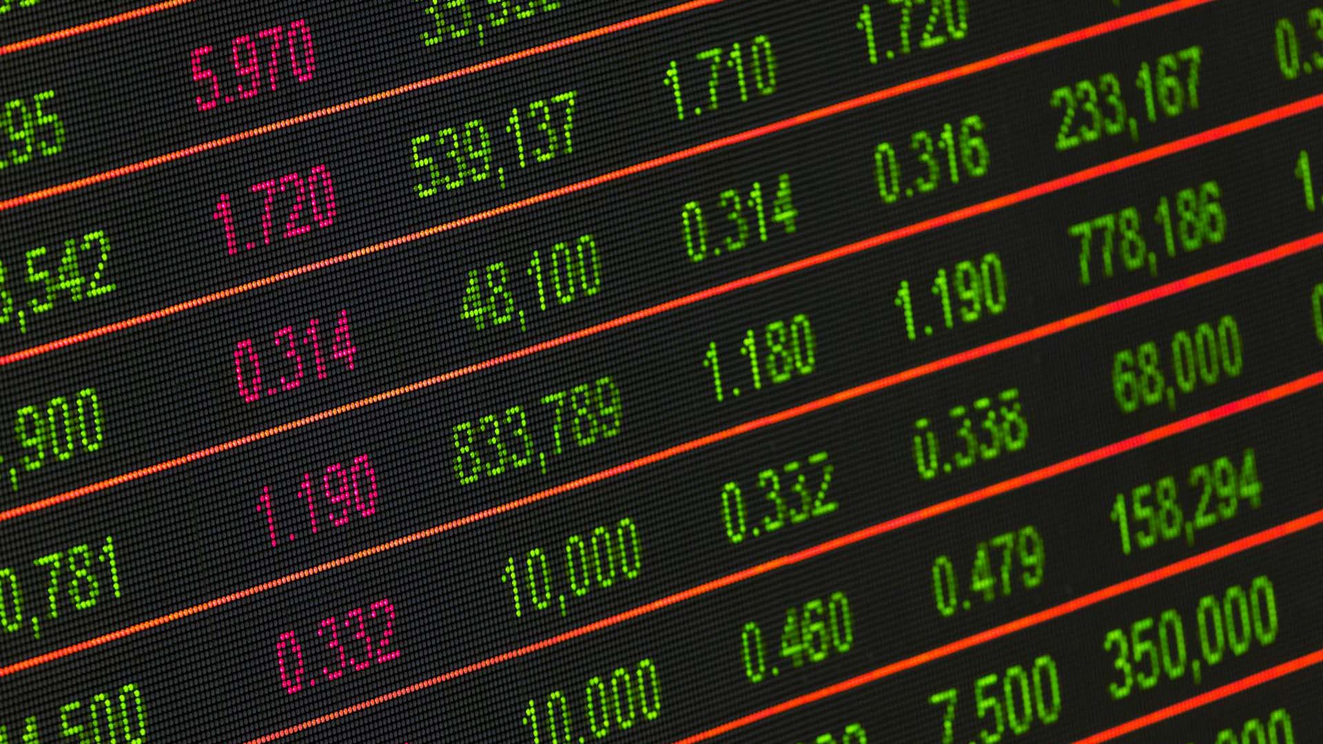 Pantalla electrónica con cotizaciones bursátiles en tiempo real, mostrando precios de acciones, variaciones y volúmenes de negociación. Dólar