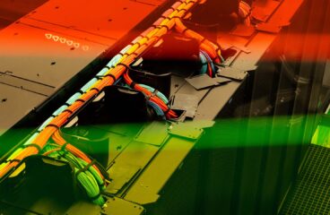 Detalle del cableado multicolor de alta velocidad del superordenador MareNostrum 5 del Barcelona Supercomputing Center, organizados en bandejas de cableado conectadas al centro de datos, con filtro de tonos rojos y verdes.