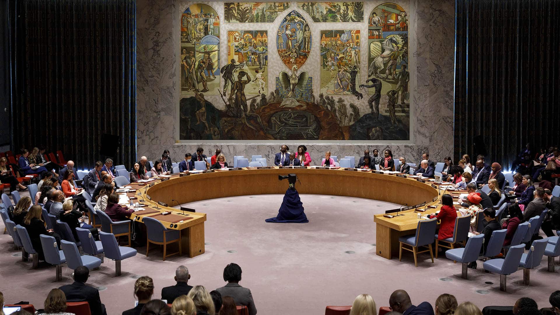 Members of the UN Security Council gathered around a circular table in the conference room with a mural in the background, to discuss the Women, Peace and Security Agenda (New York, 2022).