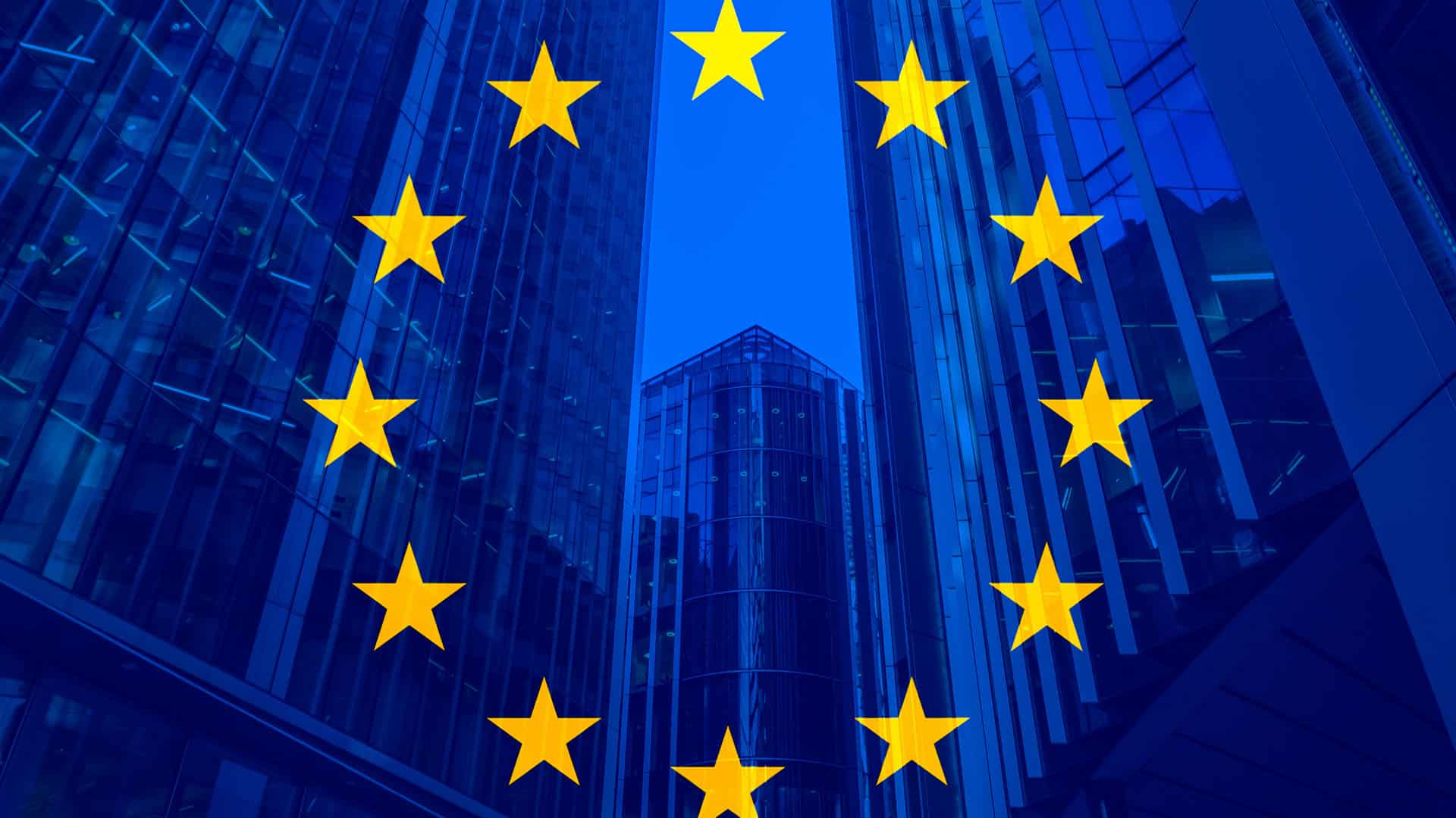 Flag of the European Union against a backdrop of modern glass buildings.
