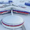 Vista aérea de la base militar Arctic Trefoil de la Federación Rusa en la isla Alexandra Land en el Ártico, con edificios circulares y rectangulares pintados en azul, rojo y blanco, rodeados de nieve.