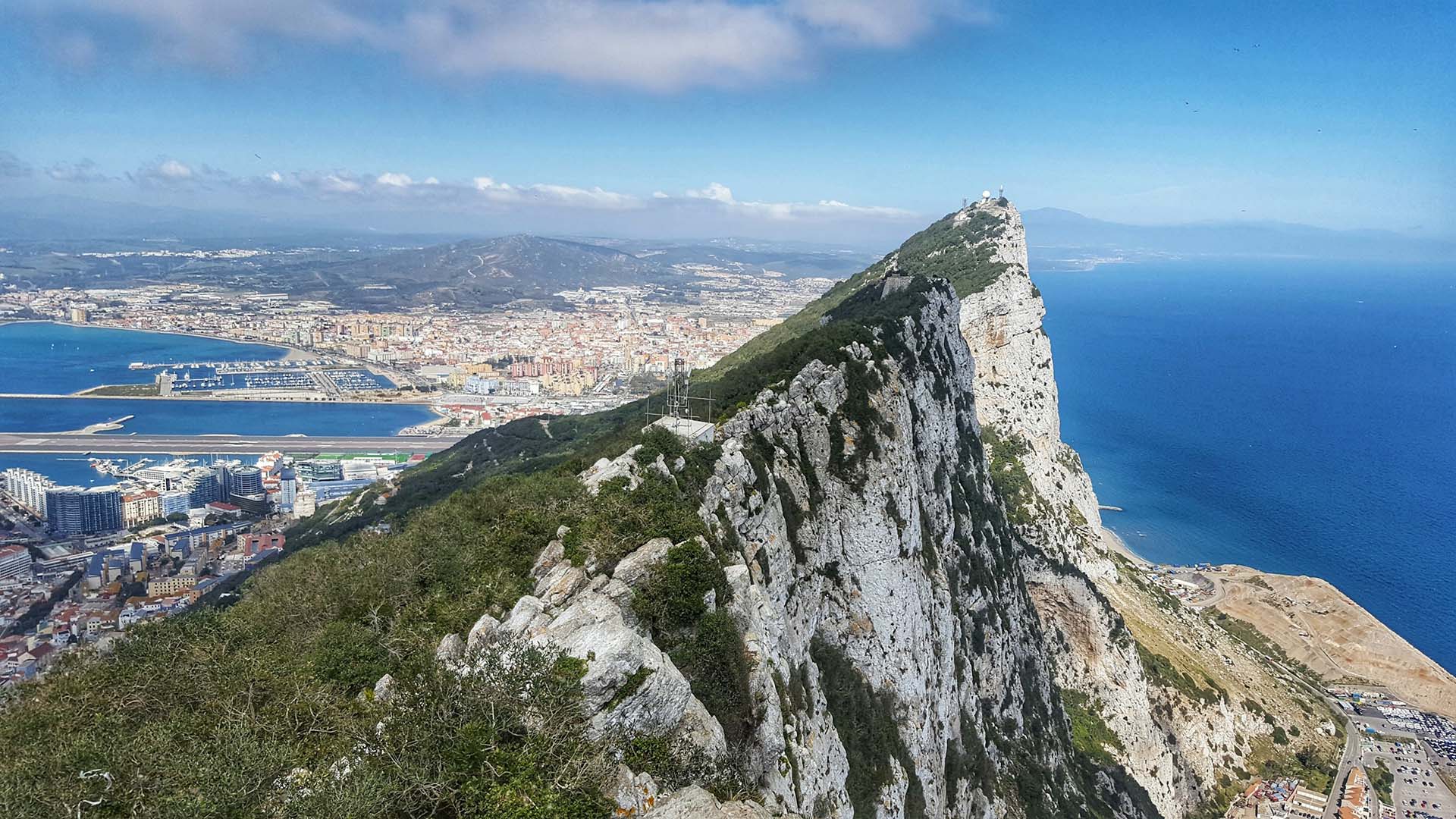 Foto del Peñón de Gibraltar en primer plano. Al fondo, el aeropuerto, el lado español y el mar Mediterráneo.