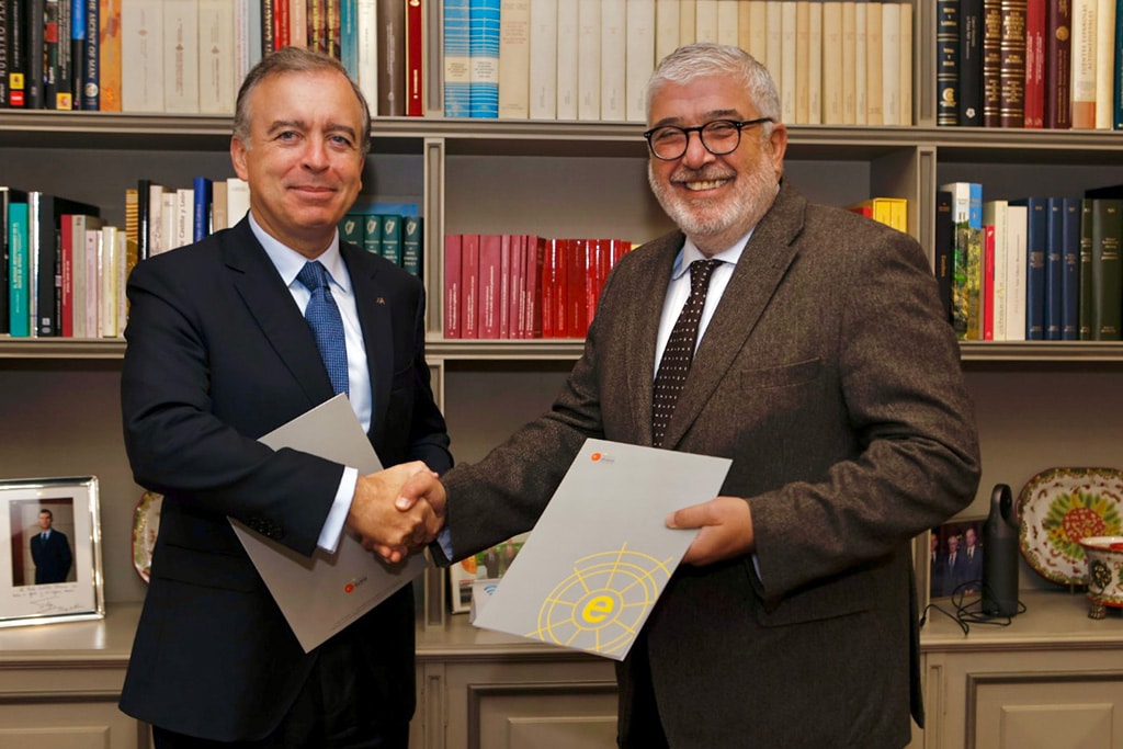 Francisco Botas Ratera, consejero delegado de ABANCA, estrecha la mano de José Juan Ruíz, presidente del Real Instituto Elcano, en un despacho frente a una biblioteca