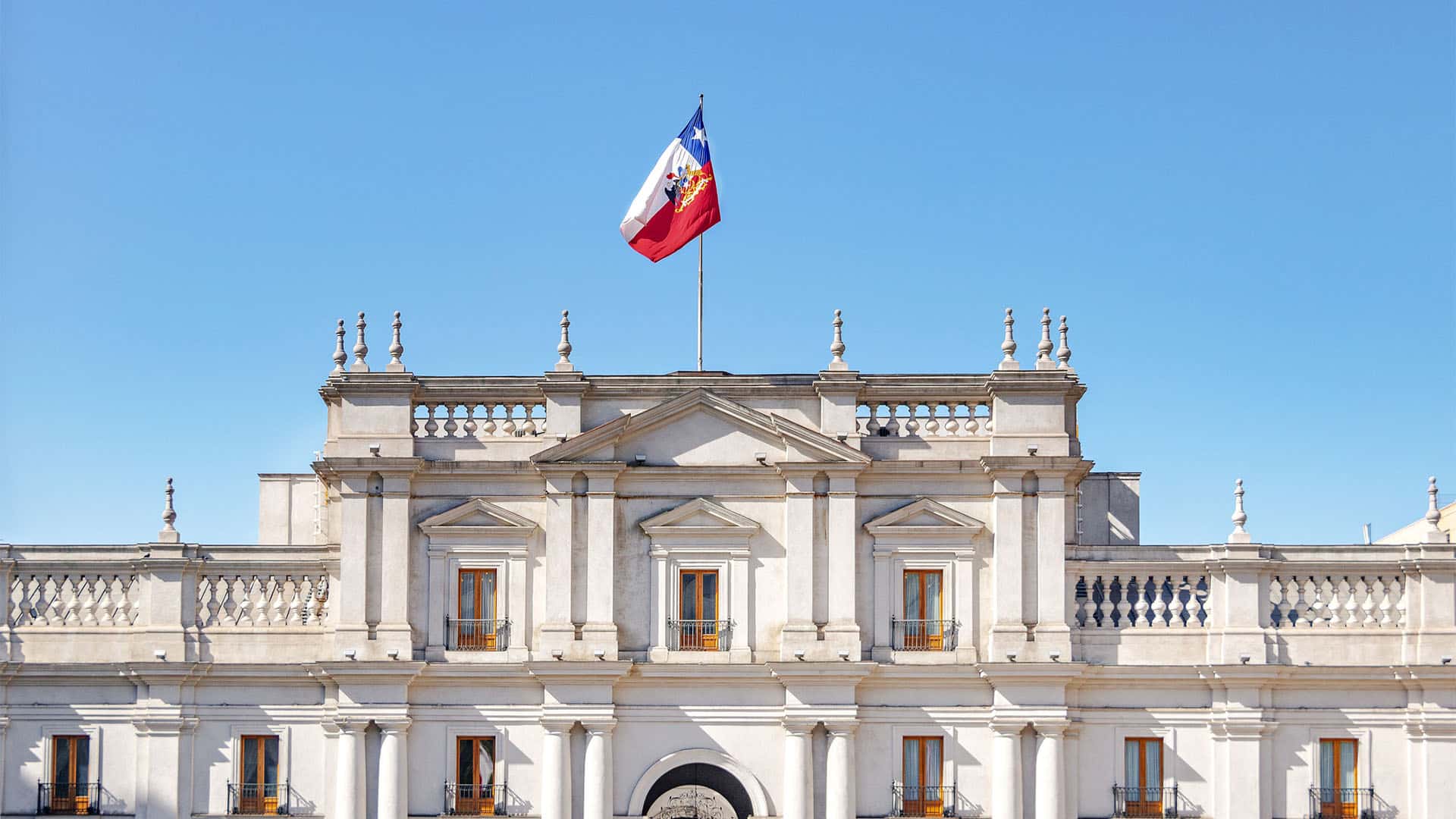 Vista de la fachada del Palacio presidencial de la Moneda en Santiago de Chile, Chile, bajo un cielo soleado (21/01/2017). En la zona superior, ondea en un mástil la bandera de Chile, que corona la cubierta del edificio presidencial.