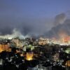 Los ataques aéreos israelíes incendian las calles de la Franja de Gaza durante un bombardeo en febrero de 2025 (10/02/2025). Los focos de los bombardeos incendian e iluminan algunas calles de la ciudad, mientras, en el fondo, una gran nube de humo oculta los edificios del horizonte y el cielo nocturno.