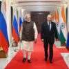 A la izquierda, Narendra Modi, primer ministro de India, y, a la derecha, Vladímir Putin, presidente de la Federación de Rusia, el 4 de diciembre en la residencia oficial del primer ministro en Nueva Delhi (7 Lok Kalyan Marg). Ambos caminan sobre una alfombra roja, flanqueada por banderas rusas en el lado de Modi y banderas indias en el lado de Putin.