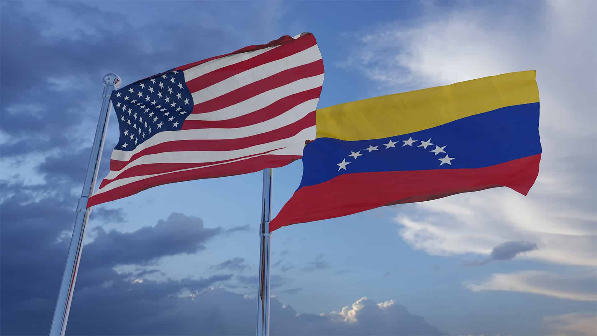 Las banderas de Estados Unidos y Venezuela ondeando en un cielo claro. (02/02/2019). En primer plano, la bandera de Estados Unidos, y, en segundo plano, la de Venezuela, ondean sobre los mástiles con un cielo claro, con algunas nubes.
