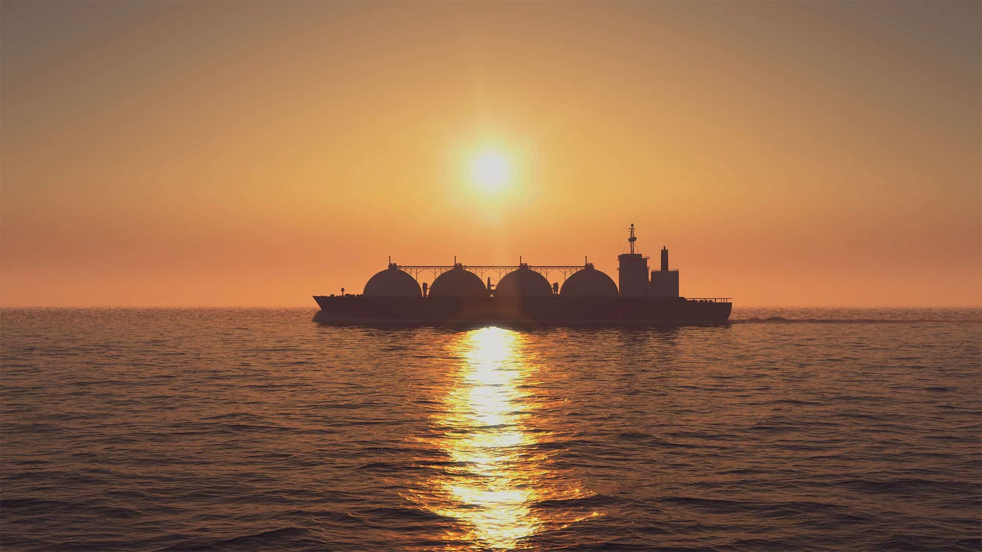 Russian LNG tanker at sunset at sea (28/04/2020). A vibrant orange sky illuminates the scene, reflected in the sea, contrasting with the tanker, which appears as a shadow on the water.