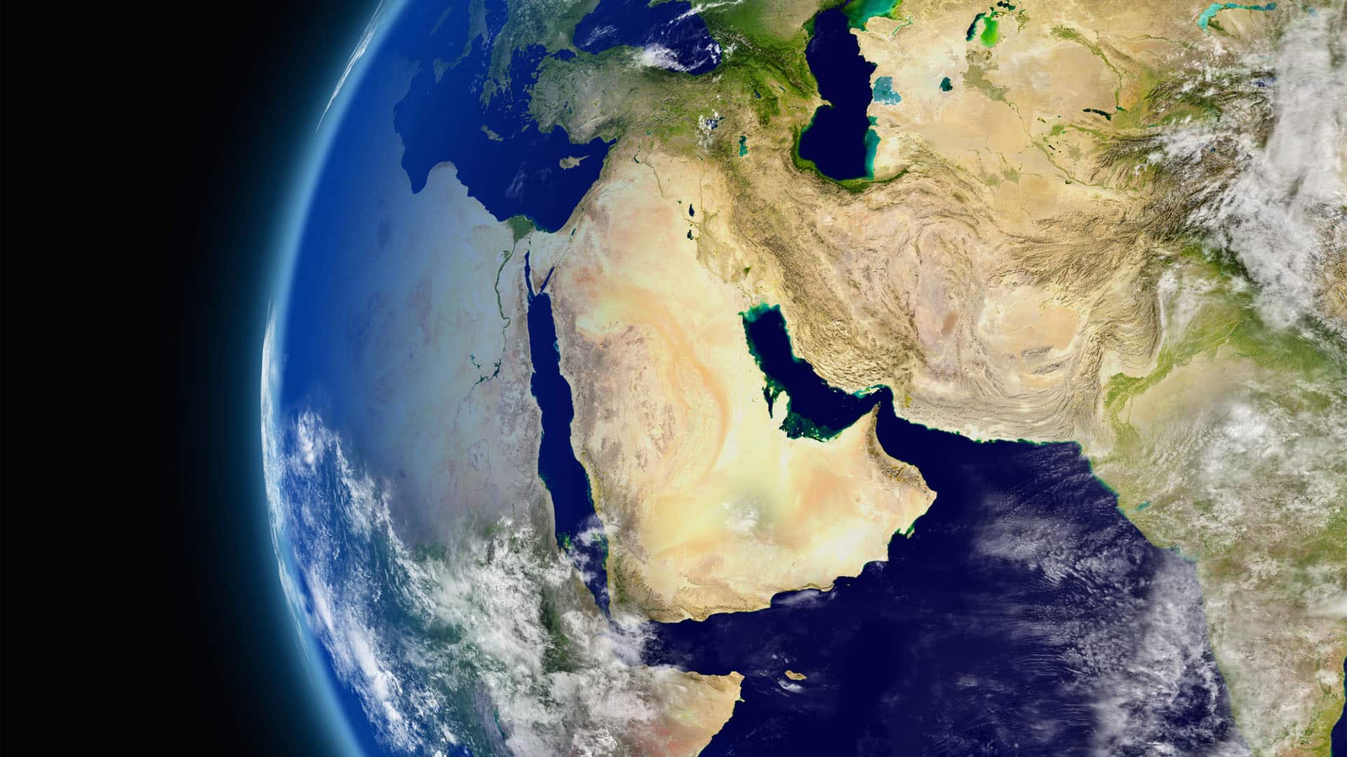Vista satelital del globo terráqueo centrada en Oriente Medio, con regiones vecinas visibles parcialmente y algunas nubes dispersas sobre la superficie. A la izquierda, la vista se enmarca por el entorno espacial.
