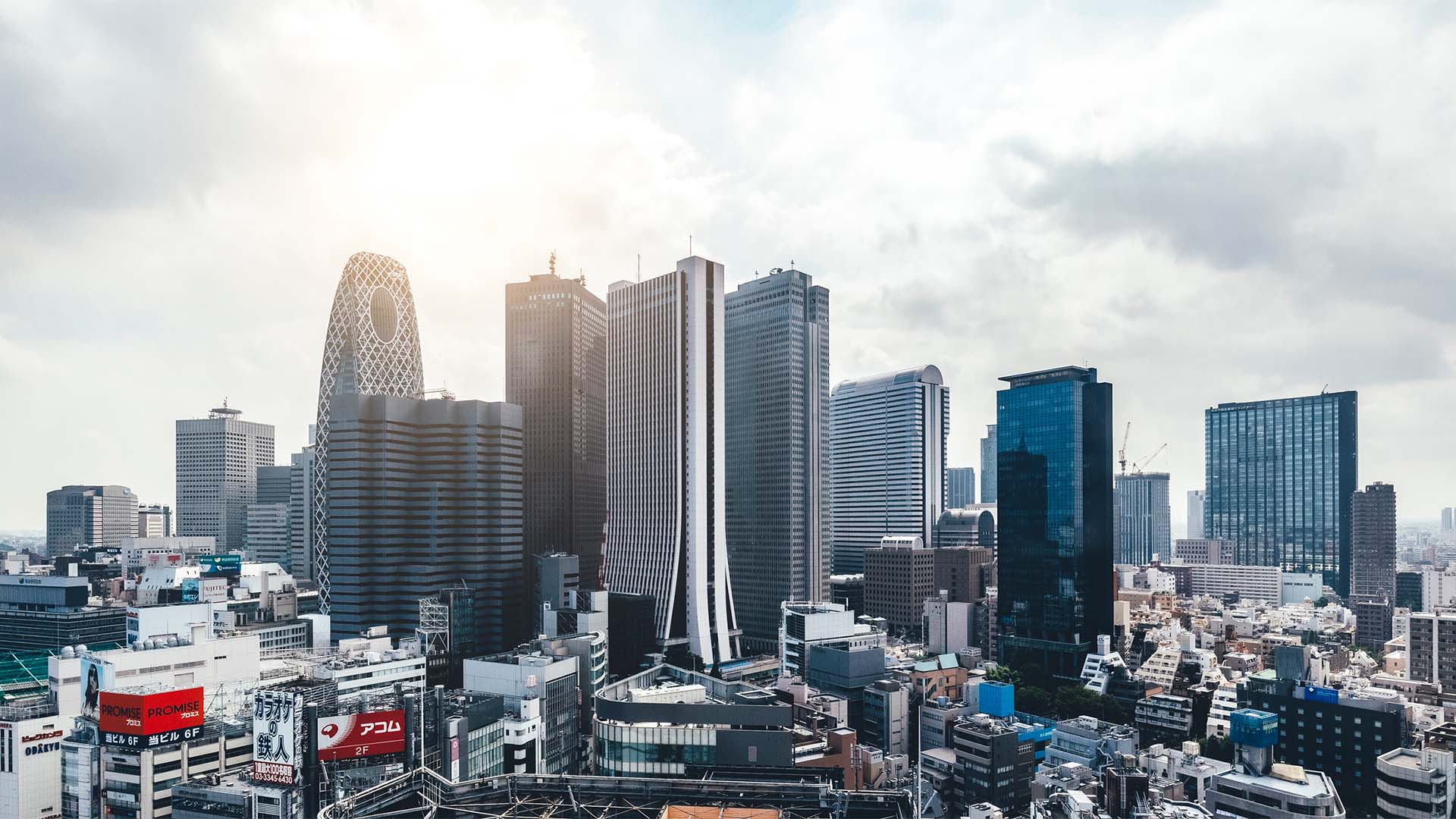 El skyline de los edificios del distrito financiero de Shinjuku destaca entre el resto de los edificios comerciales y de viviendas. Los rascacielos enmarcan un cielo claro aunque muy nublado.