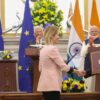 Signing of the India–EU Free Trade Agreement (27/01/2026). Kaja Kallas, EU High Representative for Foreign Affairs and Security Policy, and Dr. Subrahmanyam Jaishankar, Minister of External Affairs of India, sign the bilateral agreement. Behind them, three lecterns where Ursula von der Leyen, President of the European Commission; António Costa, President of the European Council; and Narendra Modi, Prime Minister of India, applaud. In the background, flags of the EU and India and two silver peacocks, the symbol of India, in Hyderabad House, New Delhi.