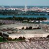 Vista aérea del Pentágono, sede del Departamento de Guerra de EEUU. Alrededor de la construcción, destacan numerosos automóviles; y, al fondo, el río Potomac y la ciudad de Washington DC.