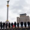 Grupo de líderes europeos reunidos en la Plaza de la Independencia en Kyiv, con motivo del cuarto aniversario de la invasión de Rusia a Ucrania. Al fondo, el capitolio con una bandera ucraniana, y detrás la columna con el monumento del Arcángel Miguel bajo el cielo nublado.