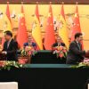 Pedro Sánchez. presidente del Gobierno de España, participa en una ceremonia de firma de acuerdos en Pekín junto al primer ministro chino, Li Qiang, mientras representantes de ambos gobiernos, entre ellos José Manuel Albares, Amparo López Senovilla y el ministro chino Wang Wentao, intercambian documentos ante una mesa oficial con banderas de España y China al fondo.