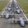 Varios aviones C-130J Super Hercules de la Fuerza Aérea de Estados Unidos regresan y se alinean sobre la pista de la base aérea de Ramstein, en Alemania. Las aeronaves están en formación sobre la pista mientras avanzan en paralelo, rodeadas de amplias zonas verdes a ambos lados de la pista de la base.