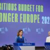 Paula Pinho, portavoz principal de la Comisión Europea (a la izquierda) y Ursula von der Leyen, presidenta de la Comisión Europea (a la derecha) hablando desde los atriles ante la prensa durante el resumen de la reunión semanal de la Comisión sobre el próximo presupuesto de la UE. A la izquierda se asoma una cámara de televisión y al fondo la pantalla azul proyecta el logo de la Comisión en fila y las palabras en inglés “An ambitious budget for a stronger Europe 2028-2034” (un presupuesto ambicioso para una Europa más fuerte 2028-2034).