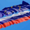 Flags of the European Union and Russia waving against a blue sky.