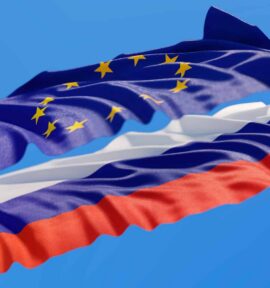 Flags of the European Union and Russia waving against a blue sky.