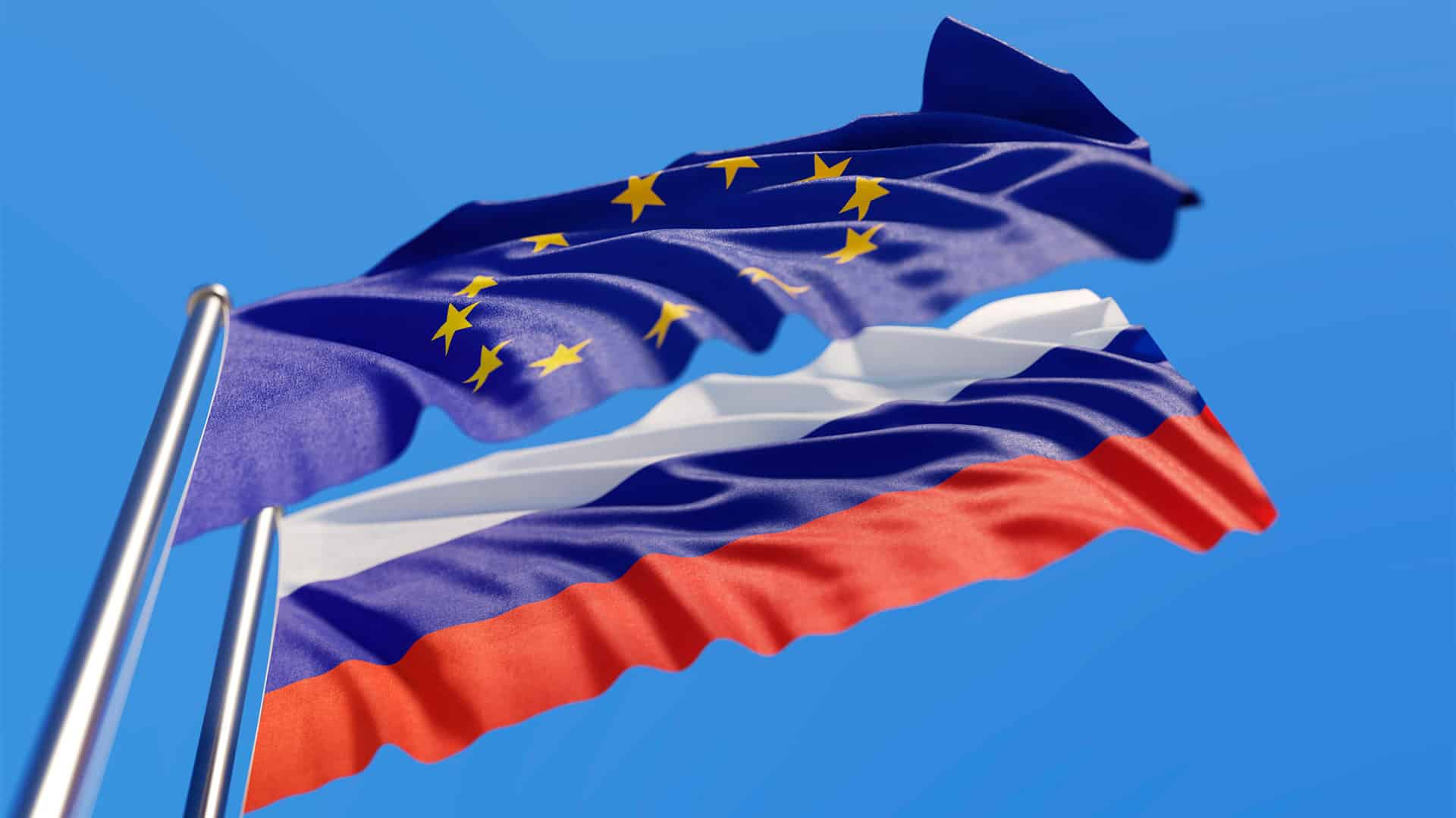 Flags of the European Union and Russia waving against a blue sky.