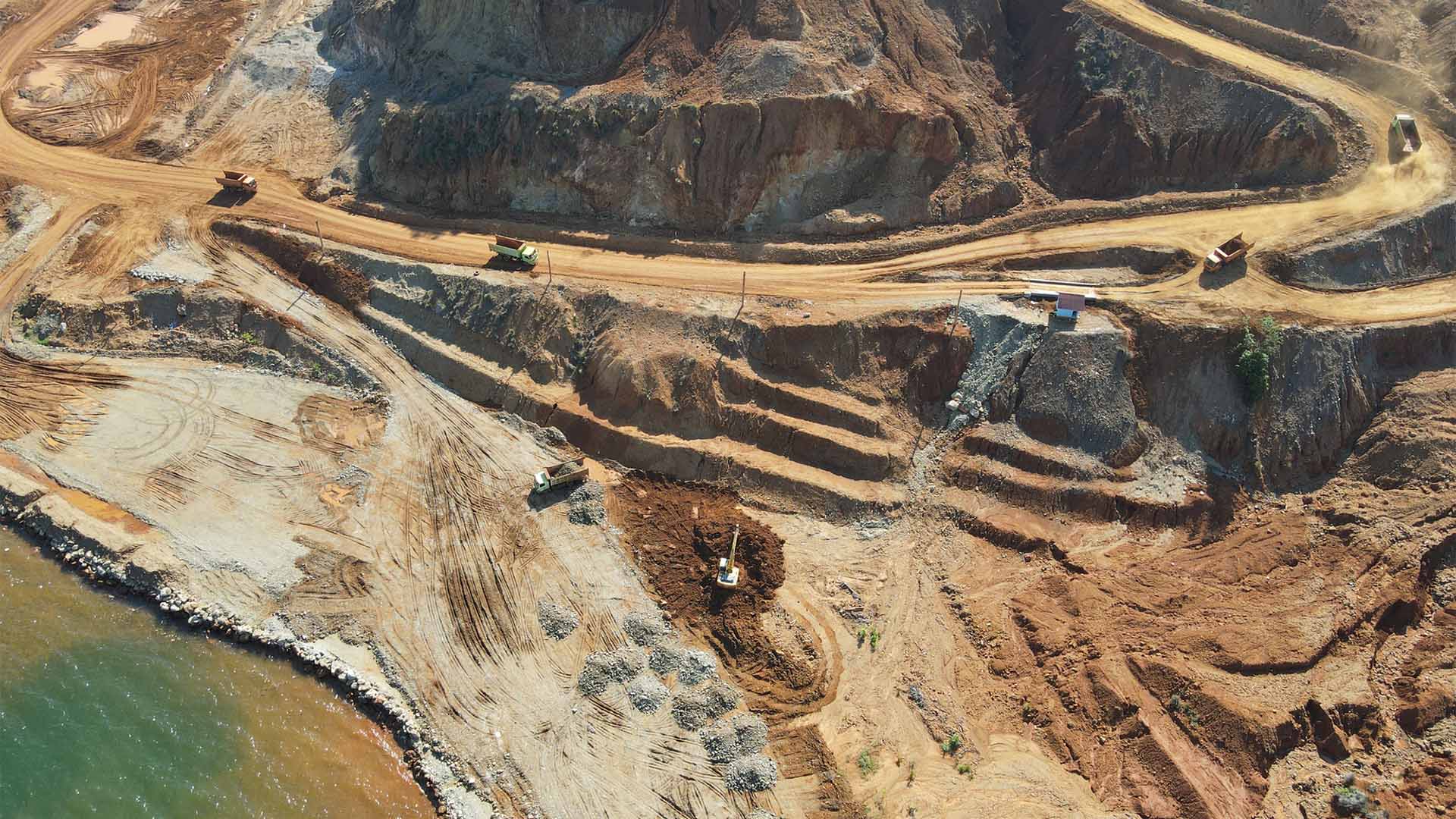 Aerial view of a nickel mine on the island of Sulawesi, Indonesia. Haul roads, excavators and lorries transporting ore between the extraction and storage areas can be seen.