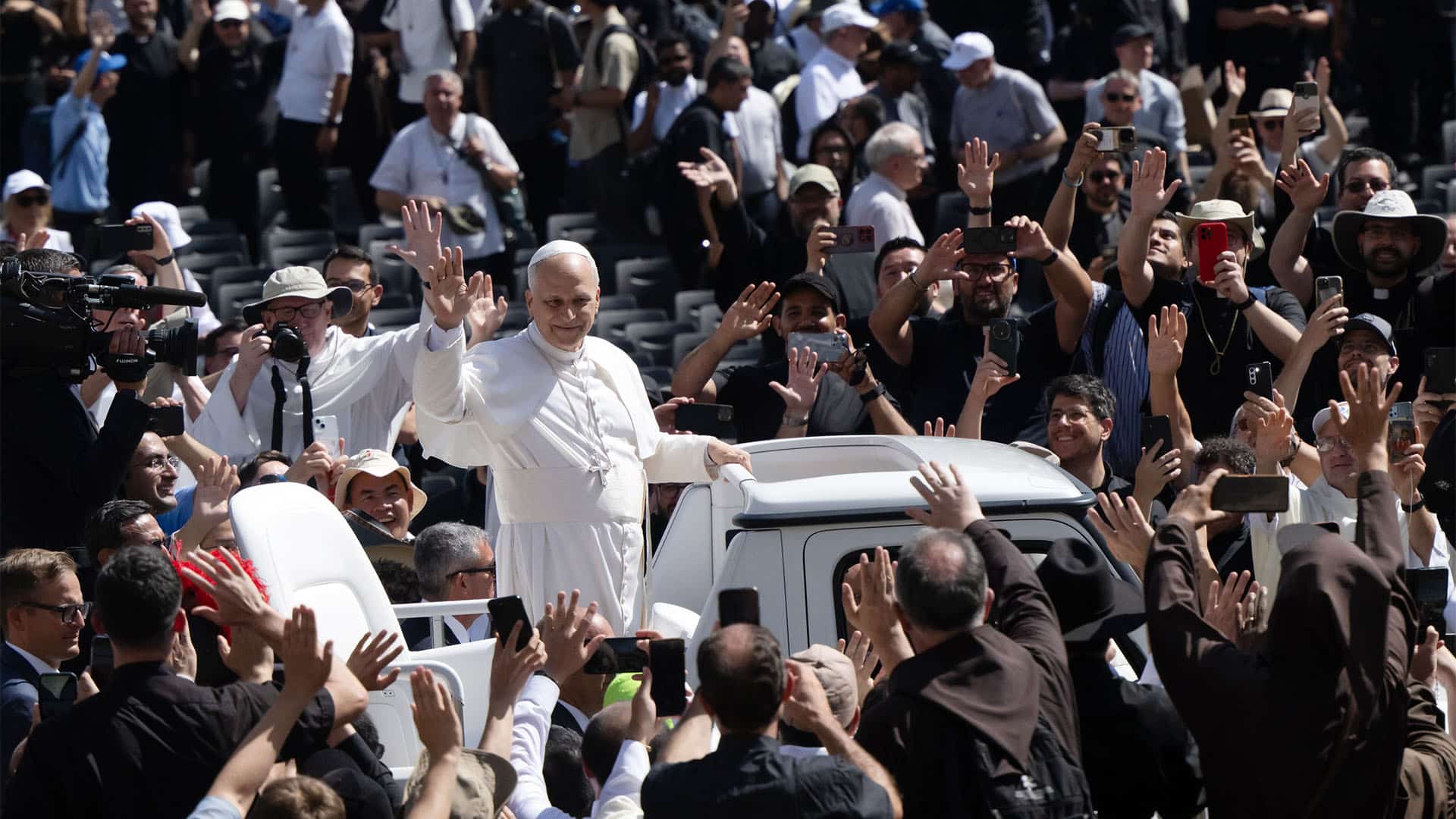 El papa León XIV saluda a los fieles desde el papamóvil durante la ceremonia de canonización de Carlo Acutis y Pier Giorgio Frassati, rodeado por una multitud congregada en la plaza de San Pedro.