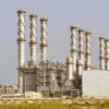 Vista exterior de la planta desaladora de Jubail, con numerosos conductos, tuberías e instalaciones industriales y varias chimeneas altas de estructura helicoidal.