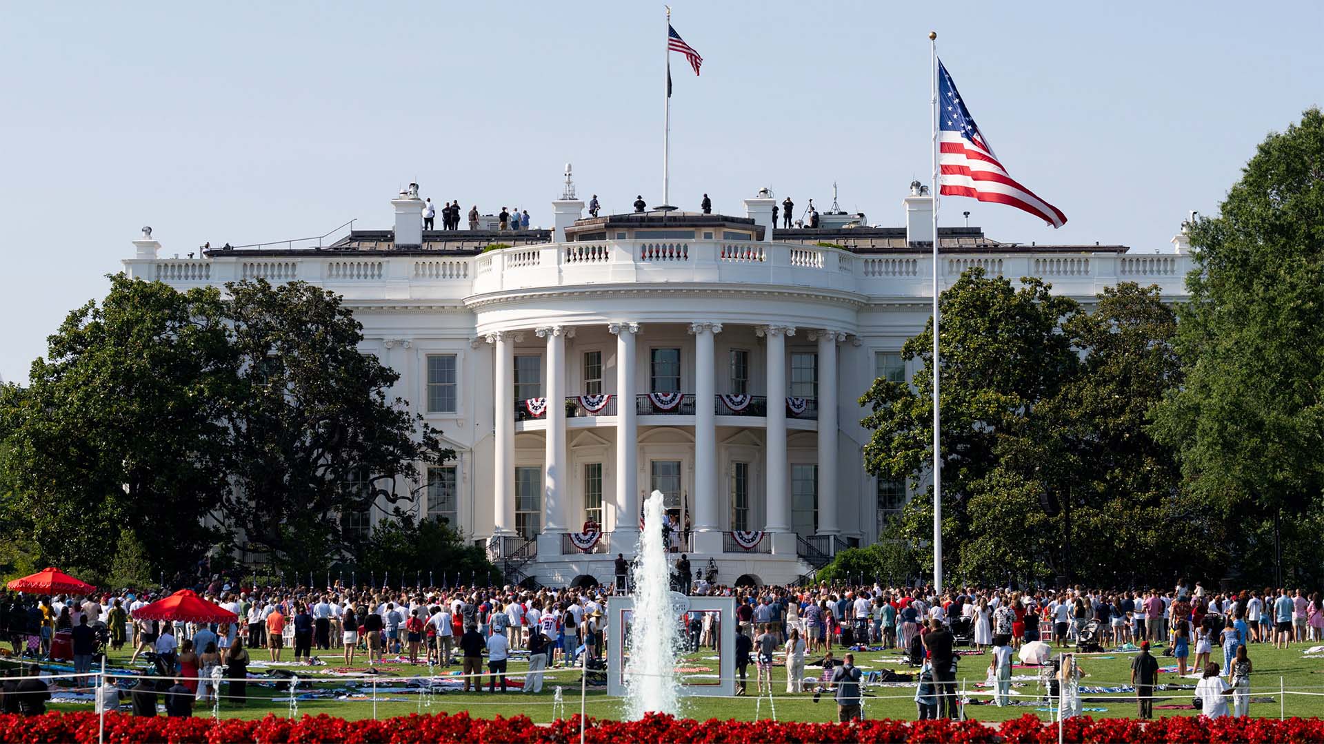 Multitud reunida frente a la Casa Blanca durante la celebración del Día de la Independencia de 2025, con banderas de Estados Unidos, y la decoración conmemorativa.