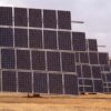 Rows of large solar panels installed on dry ground in La Albuera, Extremadura, beneath a cloudy sky.