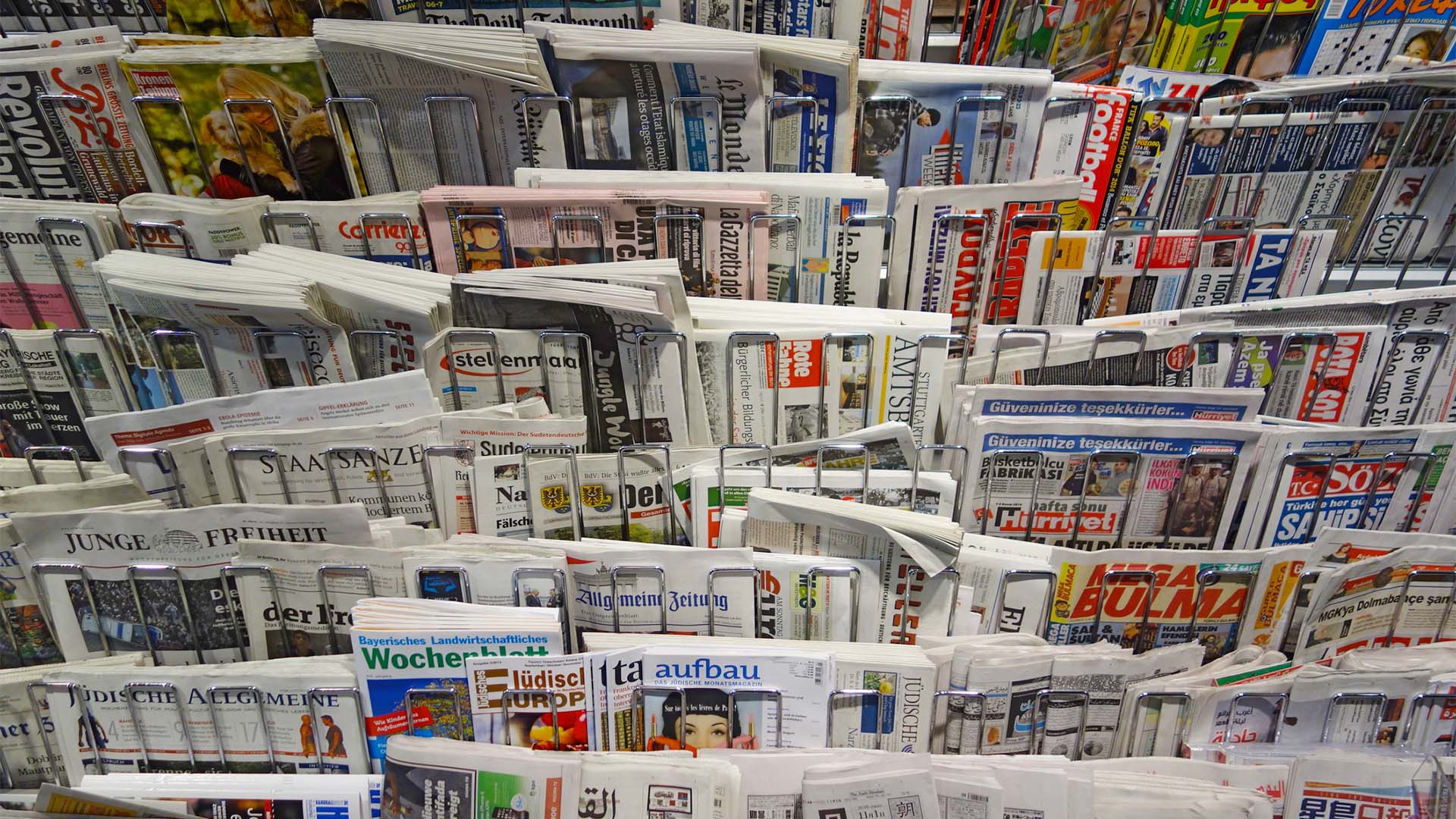 Expositor de una librería de Stuttgart con numerosos periódicos y publicaciones internacionales impresos en distintos idiomas y organizados en varias filas.