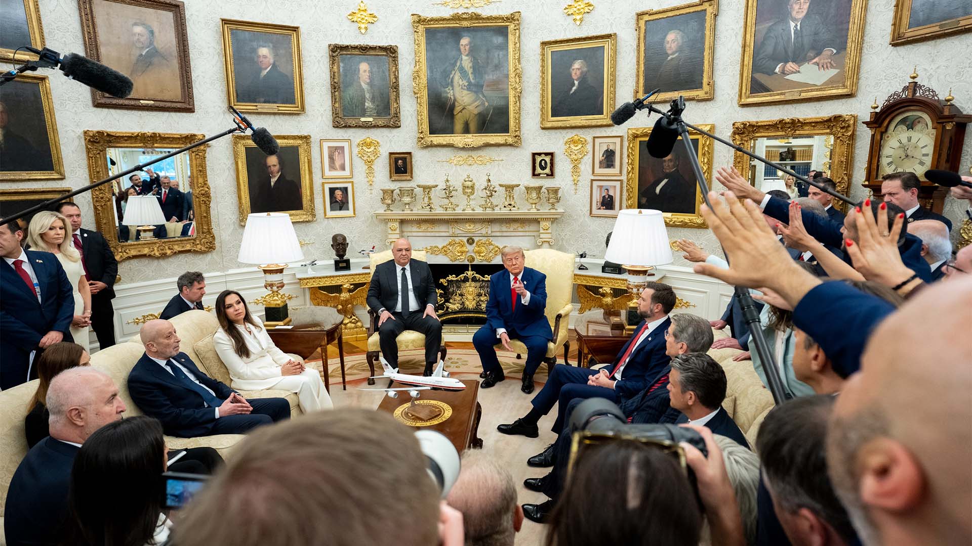 Reunión oficial el 21 de julio de 2026 en el Despacho Oval de la Casa Blanca profusamente decorado con retratos históricos enmarcados, una chimenea decorativa y mobiliario clásico con detalles dorados. Frente a la chimenea, Joseph Auon (presidente de Líbano) y Donald Trump (presidente de EEUU). Sentados a los lados de una mesa de centro, los representantes de Líbano (izquierda) y de EEUU (derecha), mientras periodistas, cámaras y micrófonos rodean la reunión con micrófonos suspendidos sobre los participantes.