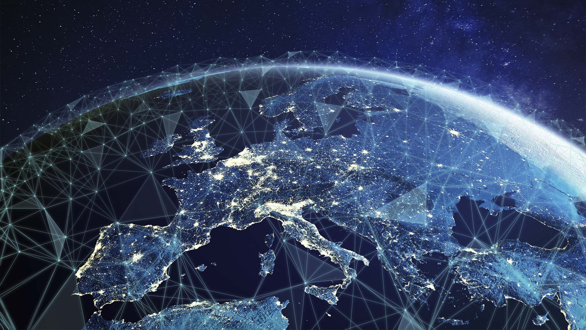 Vista nocturna de Europa desde el espacio, con las principales zonas urbanas iluminadas y una red de líneas y nodos digitales superpuesta sobre el continente.