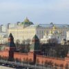 Vista panorámica del Kremlin de Moscú, con sus murallas y torres de ladrillo rojo en primer plano y el Gran Palacio del Kremlin y varias catedrales de cúpulas doradas al fondo.