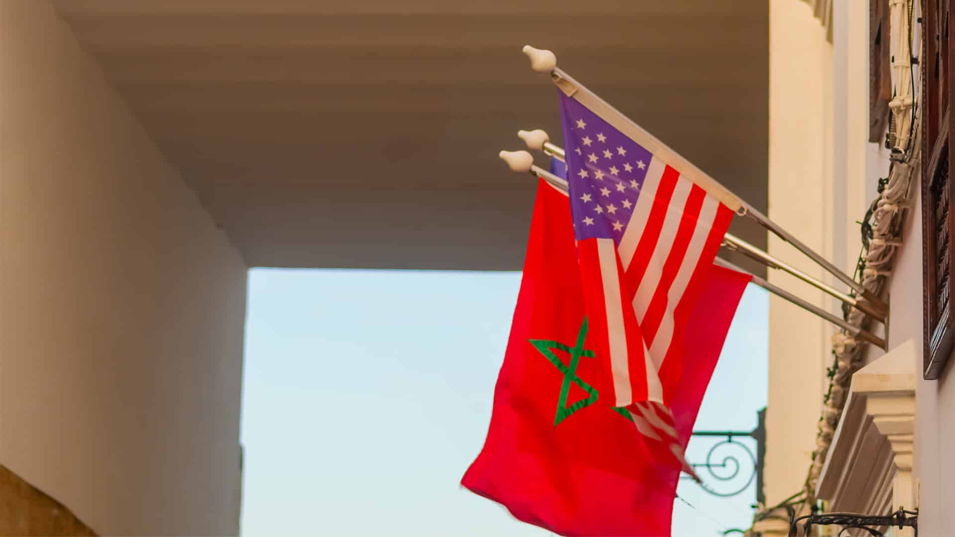 Banderas nacionales de Estados Unidos y Marruecos instaladas en astas en la fachada de un edificio de una calle de Tánger, Marruecos.