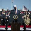 Donald Trump interviene ante un atril con el sello presidencial durante un acto conmemorativo del 25 aniversario del 11S al aire libre en Washington, rodeado de miembros de las fuerzas de seguridad y del Ejército, con banderas de Estados Unidos al fondo.