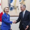 Ursula von der Leyen, presidenta de la Comisión Europea, y Mark Carney, primer ministro de Canadá, se estrechan la mano durante una reunión, con las banderas de Canadá y la Unión Europea al fondo.