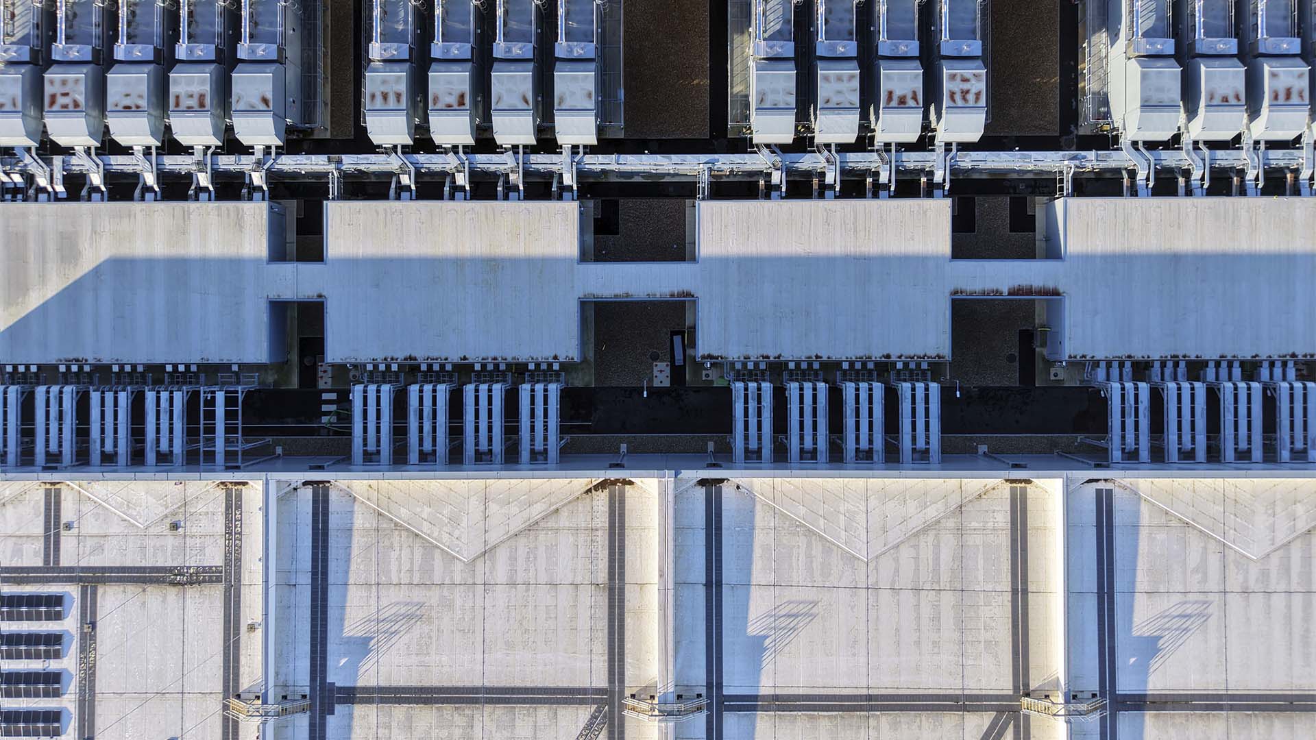 Vista aérea de un gran centro de datos en Londres, con varias filas de instalaciones y sistemas de refrigeración distribuidos sobre la cubierta del edificio.