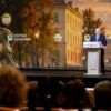 Vladímir Putin interviene desde un atril ante el público durante el XII Foro Internacional de las Culturas Unidas de San Petersburgo, con una gran pantalla de fondo que muestra una imagen de la ciudad.