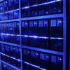 Rows of servers and computer equipment installed in metal racks and illuminated by blue lights at the BalticServers data centre, Lithuania.