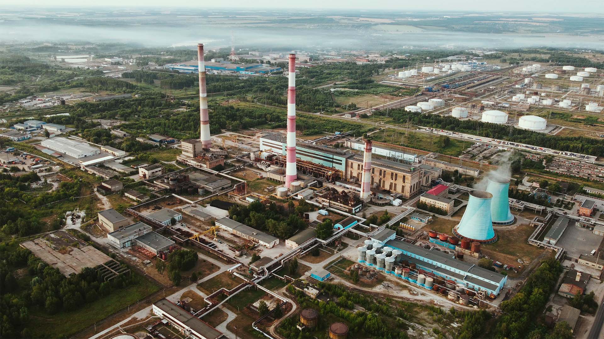 Vista aérea de una gran refinería de petróleo con numerosas torres industriales, tuberías y depósitos, rodeada por terrenos abiertos. La imagen ilustra la infraestructura energética rusa vinculada al refino y la comercialización de combustibles.