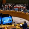 Sesión del Consejo de Seguridad de la ONU sobre inteligencia artificial y seguridad internacional, con representantes de distintos países sentados alrededor de una mesa circular, incluido Sam Altman (OpenAI) y las intervenciones de Dario Amodei (Anthropic) y Clem Delangue (Hugging Face) conectados por videoconferencia mostrados en las cinco pantallas centrales.