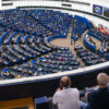 A panoramic view of the European Parliament’s chamber during the plenary session on the EU’s 2028-2034 budget (MFF) and competitiveness, among other topics (6/10/2026), with hundreds of MEPs taking their seats and the flags of the Member States flying alongside the EU flag.